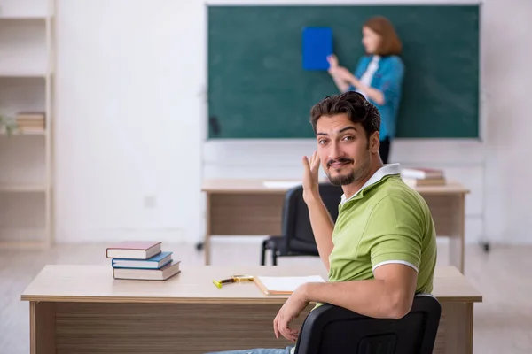 Mladý učitel a student ve třídě — Stock fotografie