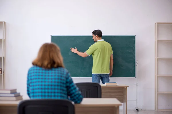 Joven profesor y estudiante en el aula — Foto de Stock