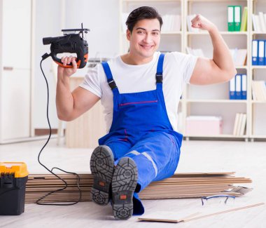 Zemin kaplamalarında çalışan genç bir işçi.