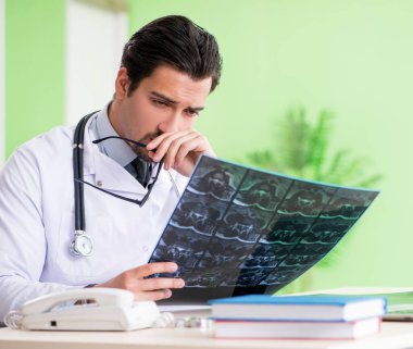 Doktor radyoloji uzmanı hastanede röntgen taramasına bakıyor.