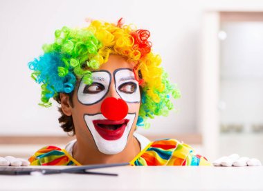 Erkek palyaço evde performansa hazırlanıyor.