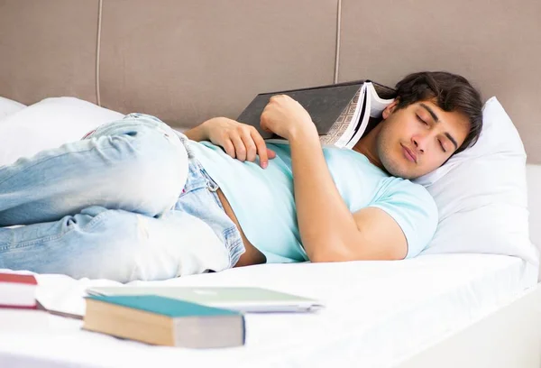 Φοιτητής που προετοιμάζεται για τις εξετάσεις στο σπίτι στο υπνοδωμάτιο ξαπλωμένος στο κρεβάτι — Φωτογραφία Αρχείου