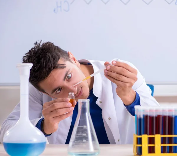 De jonge chemicus zit in het lab. — Stockfoto