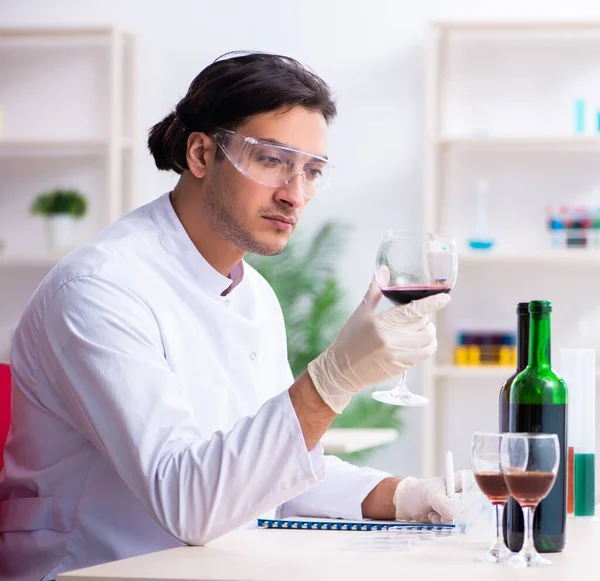 Male chemist examining wine samples at lab — Stock Photo, Image