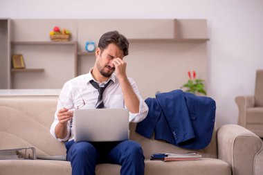 Genç erkek çalışan salgın sırasında evden çalışıyor.