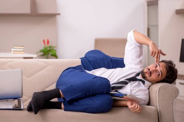 Genç erkek çalışan salgın sırasında evden çalışıyor.