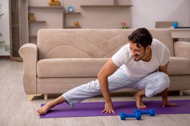 Genç adam evde spor yapıyor.