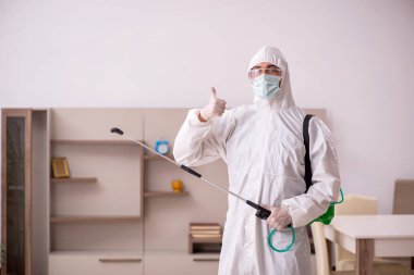 Genç erkek müteahhit evde haşere kontrolü yapıyor.