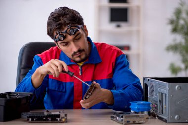 Bilgisayar tamir eden genç bir erkek tamirci.