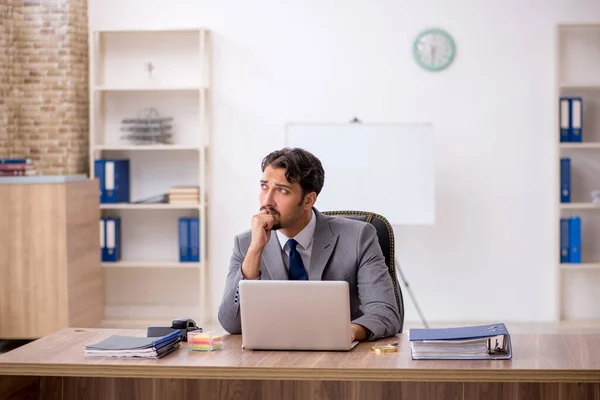 Joven empleado masculino sentado en la oficina — Foto de Stock