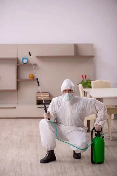 Jovem empreiteiro fazendo controle de pragas em casa — Fotografia de Stock