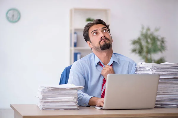 Jeune employé masculin et trop de travail au bureau — Photo