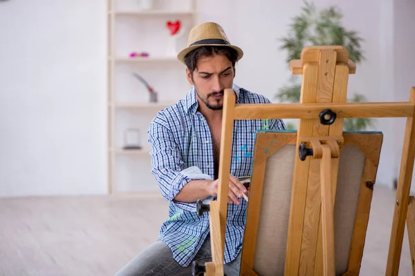 Молодой человек наслаждается живописью в студии — стоковое фото