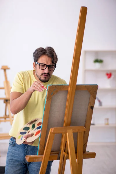 Młody człowiek cieszący się malowaniem w domu — Zdjęcie stockowe