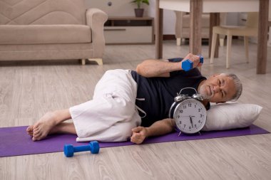 Yaşlı adam evde spor yapıyor.