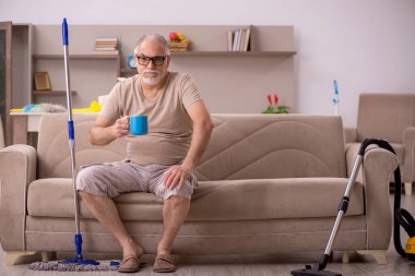 Yaşlı adam evde ev işi yapıyor.