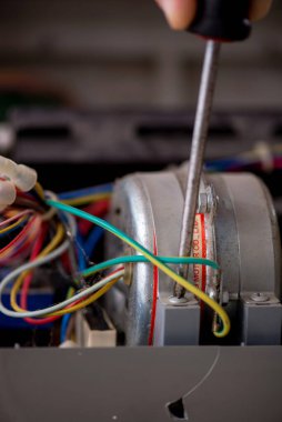 Eski tamirci atölyedeki klimayı tamir ediyor.