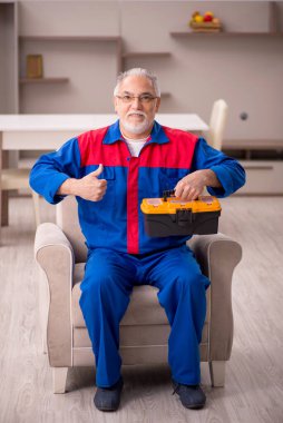 Yaşlı erkek marangoz içeride çalışıyor.