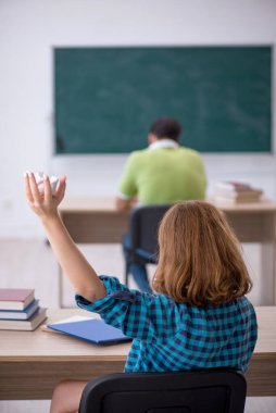 İki öğrenci sınıfta eğleniyor.