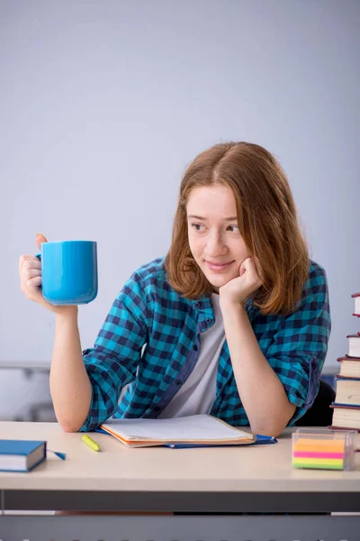 Jonge vrouwelijke student die koffie drinkt tijdens de pauze — Stockfoto