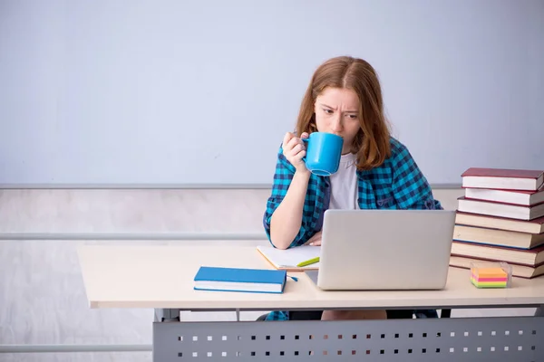 Молодая студентка пьет кофе во время перерыва — стоковое фото