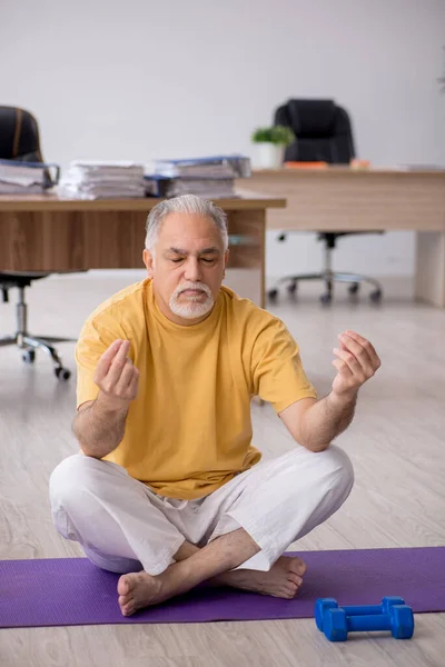 Velho empresário empregado fazendo exercícios esportivos no escritório — Fotografia de Stock