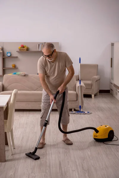 Staruszek robi prace domowe w domu — Zdjęcie stockowe