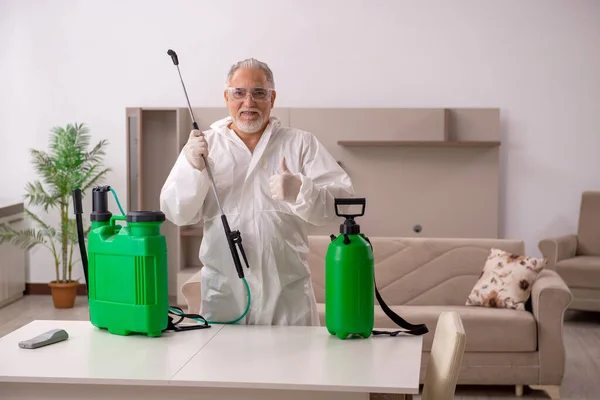 Viejo contratista masculino haciendo control de plagas en casa —  Fotos de Stock