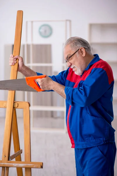 Yaşlı erkek marangoz çizim sehpasını kesiyor — Stok fotoğraf