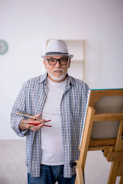Старику нравится рисовать дома — стоковое фото