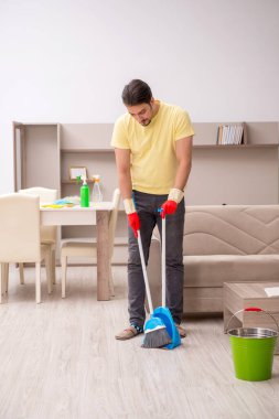 Genç erkek müteahhit evi temizliyor.