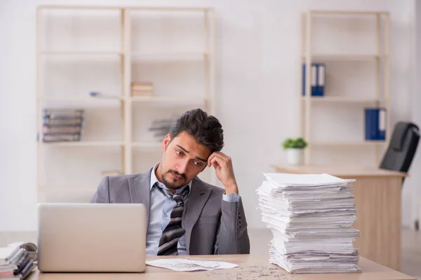 Jovem funcionário masculino infeliz com excesso de trabalho no escritório — Fotografia de Stock