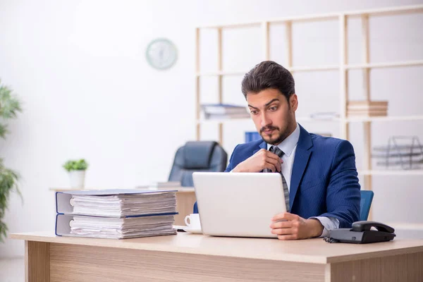 Jovem e bonito empregado que trabalha no escritório — Fotografia de Stock