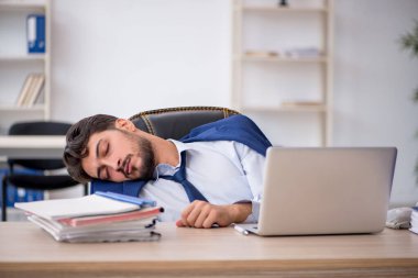Genç erkek çalışan ofiste çok yorgun.
