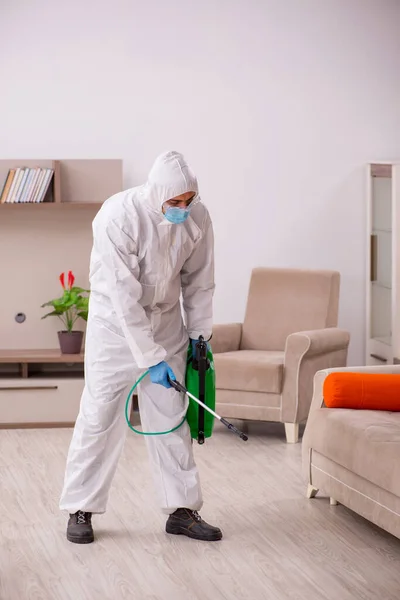 Young male contractor disinfecting at home — Stockfoto