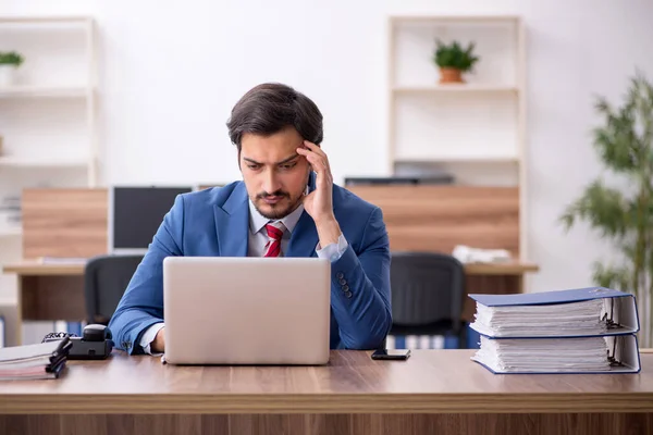 Junge männliche Mitarbeiter sitzen am Arbeitsplatz — Stockfoto