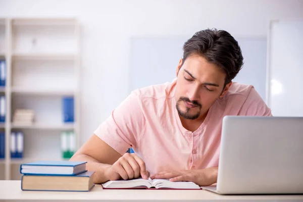 Ung manlig student förbereder sig för tentor i klassrummet — Stockfoto