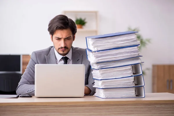 Young male employee unhappy with excessive work in the office — Stock Photo, Image