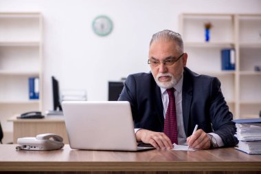 Ofiste çalışan yaşlı bir erkek.