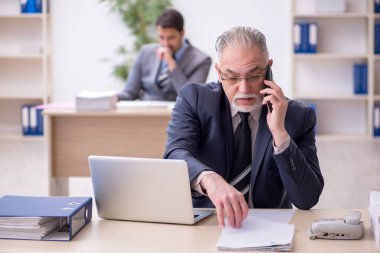 Ofiste çalışan iki erkek çalışan.