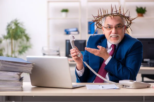Starý muž zaměstnanec nosí pichlavý věnec na hlavě — Stock fotografie