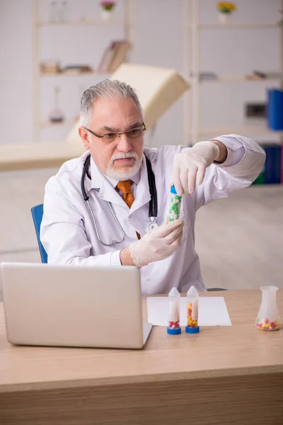 Gammal manlig läkare farmaceut som arbetar på kliniken — Stockfoto