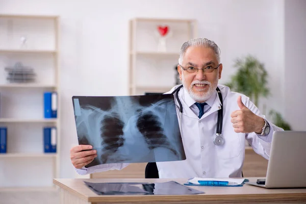 Gammal manlig röntgenläkare som arbetar på kliniken — Stockfoto