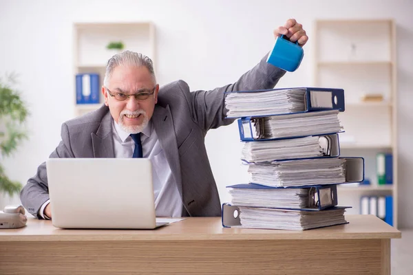 Old male employee unhappy with excessive work in the office — Stock Photo, Image