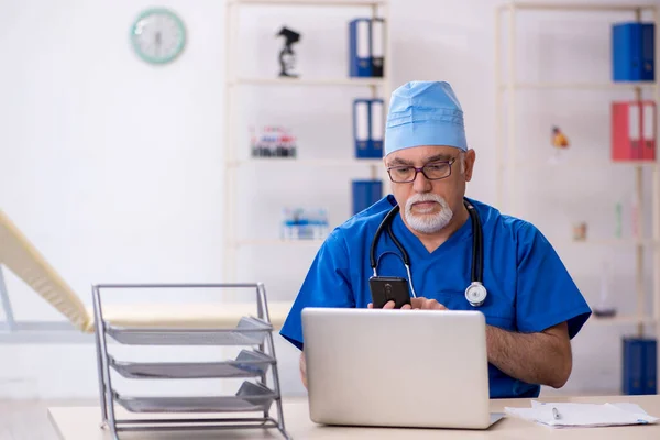 Starý lékař pracující na klinice — Stock fotografie