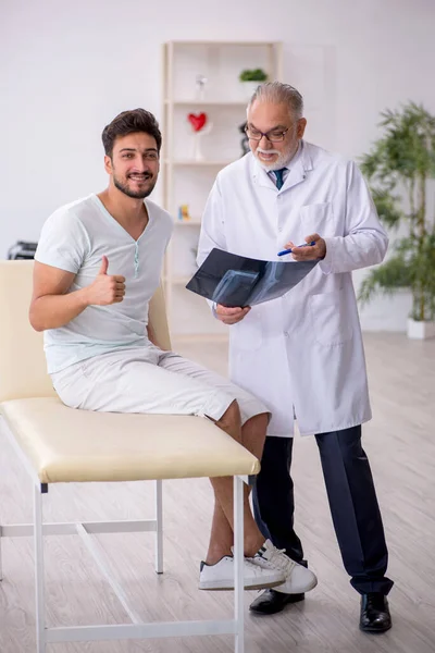 Genç erkek hasta yaşlı erkek doktor radyolojisti ziyaret ediyor. — Stok fotoğraf