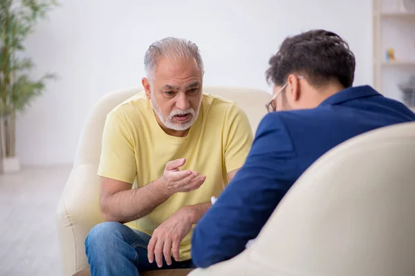 Старий відвідує молодого чоловіка психотерапевта — стокове фото