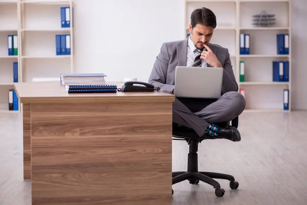 Junge attraktive männliche Mitarbeiter sitzen am Arbeitsplatz — Stockfoto