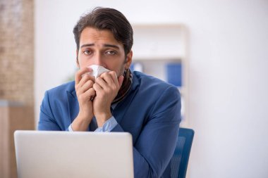 İş yerinde acı çeken genç bir erkek işçi.