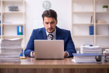 Ofisteki aşırı işten memnun olmayan genç bir erkek işçi.